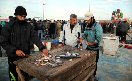 Men clean fish at a market in Gaza City, after Israel expanded fishing zone for Palestinians April 2, 2019. REUTERS/Suhaib Salem