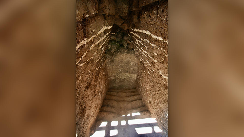 Photograph of mudbrick stairs through narrow passageway.