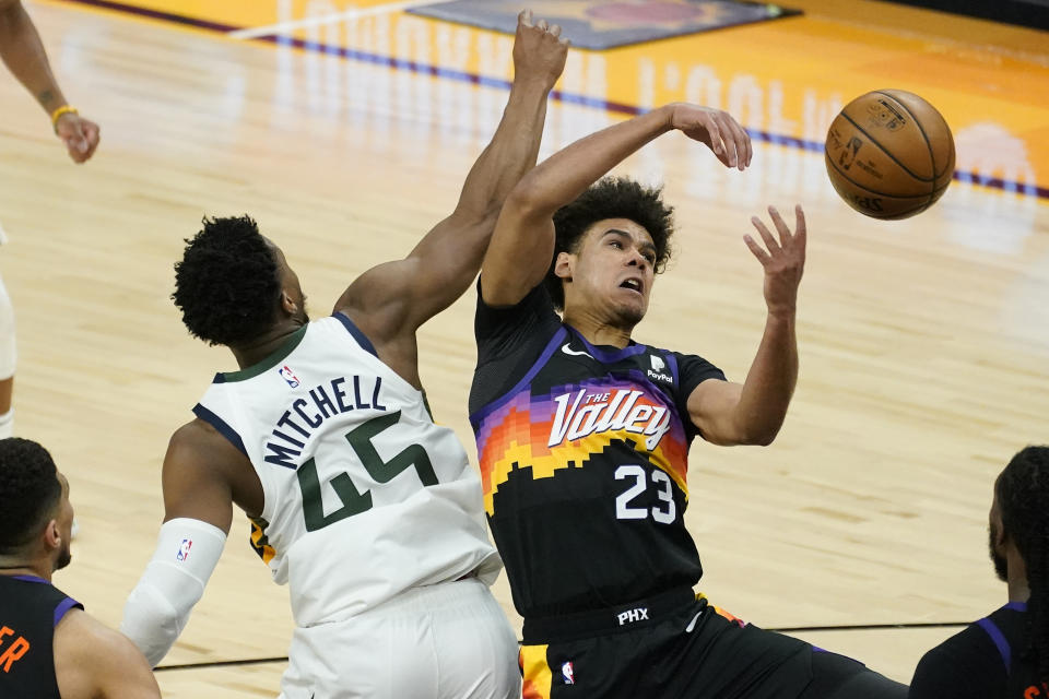 Phoenix Suns forward Cameron Johnson (23) battles Utah Jazz guard Donovan Mitchell (45) for the ball during the second half of an NBA basketball game, Wednesday, April 7, 2021, in Phoenix. (AP Photo/Matt York)