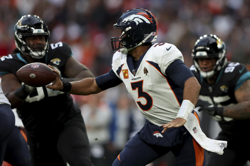 Denver Broncos quarterback Russell Wilson (3) hands off the ball during the NFL football game between Denver Broncos and Jacksonville Jaguars at Wembley Stadium in London, Sunday, Oct. 30, 2022. (AP Photo/Ian Walton)