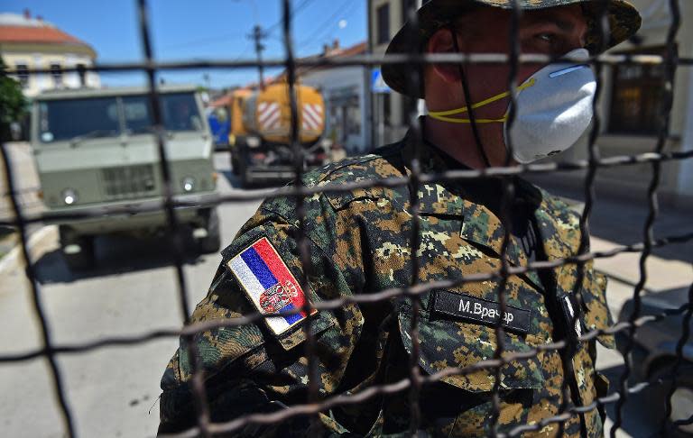 A Serbian officer escorts journalists to the town of Obrenovac, 40 kilometers west of Belgrade, on May 22, 2014