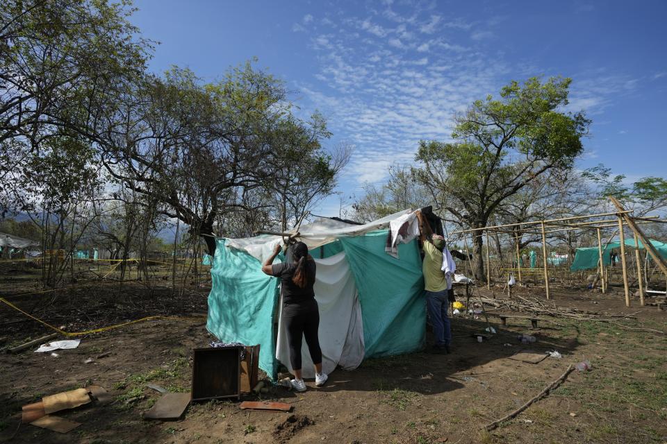 Personas que ocuparon tierras de forma ilegal desmontan su tienda de campaña improvisada después de que la policía desalojó, el día anterior, a más de 500 familias de un terreno en Neiva, Colombia, el jueves 29 de septiembre de 2022. (Foto AP/Fernando Vergara)