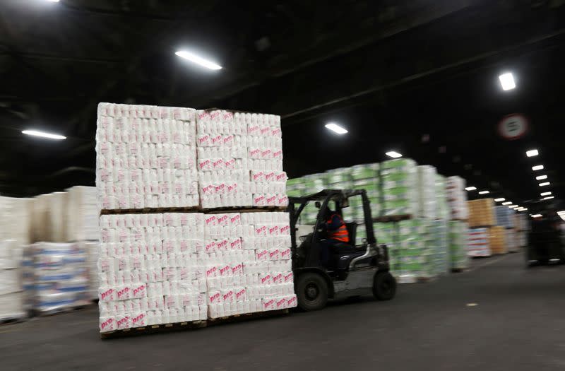 FILE PHOTO: An employee operates a forklift to move pallets of toilet paper at a warehouse of the Syassky Pulp & Paper Mill in Syasstroy