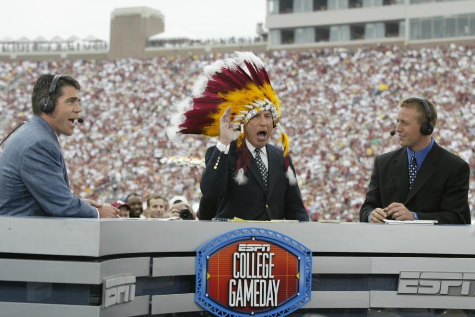 TALLAHASSEE, FL – OCTOBER 26: ESPN College GameDay announcer Lee Corso dons an FSU headress as co-announcers (l to r) Chris Fowler and Kirk Herbstreit comment during the NCAA football game between Notre Dame and Florida State at Doak Campbell Stadium on October 26, 2002 in Tallahassee, Florida. The Notre Dame Fighting Irish defeated the Florida State Seminoles 34-24. (Photo by Craig Jones/Getty Images)
