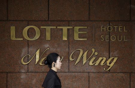 An employee walks past the logo of Lotte Hotel at a Lotte Hotel in Seoul, South Korea, March 25, 2016. REUTERS/Kim Hong-Ji