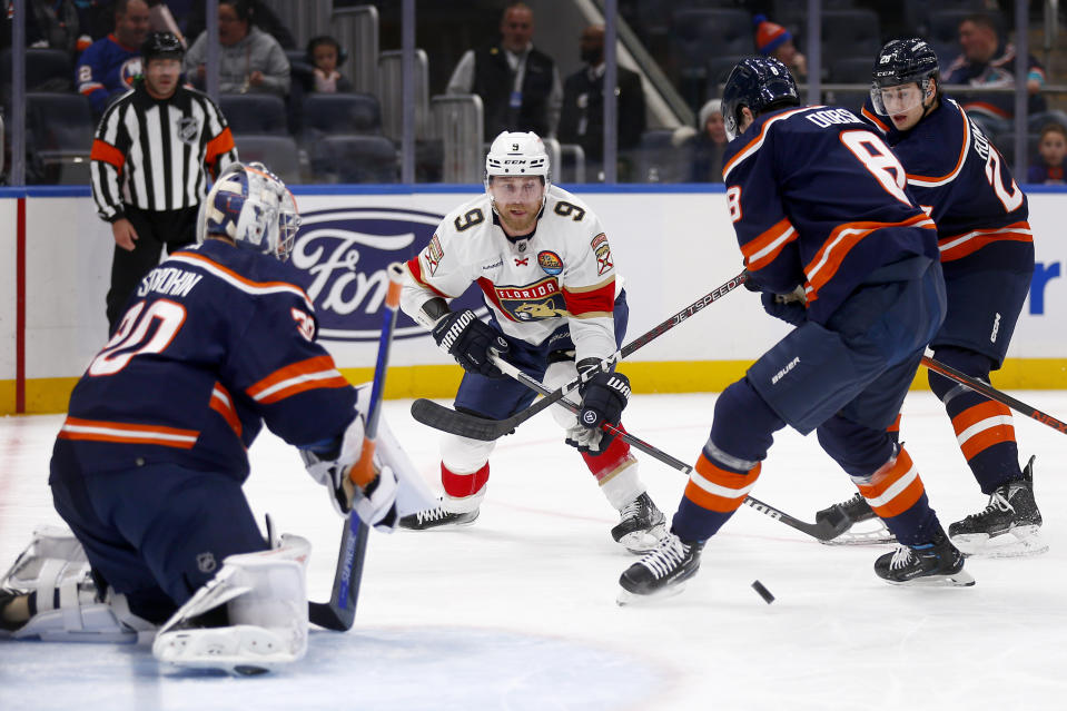 Florida Panthers center Sam Bennett (9) skates to the net against New York Islanders goalie Ilya Sorokin, left, and defensemen Noah Dobson (8) and Alexander Romanov during the first period of an NHL hockey game Friday, Dec. 23, 2022, in Elmont, N.Y. (AP Photo/John Munson)