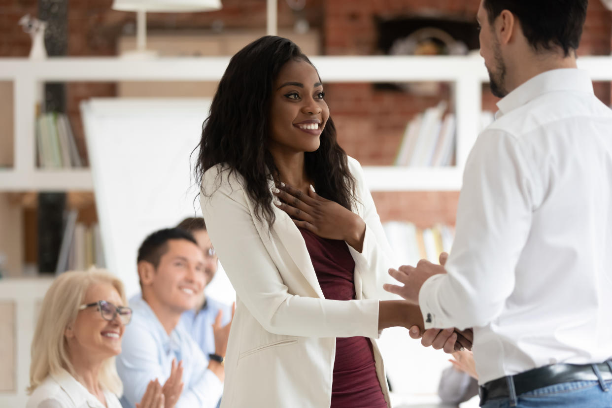 Happy black female employee get rewarded for professional achievement handshake boss, tolerant male manager shake hand of proud african business woman promote express recognition at work concept