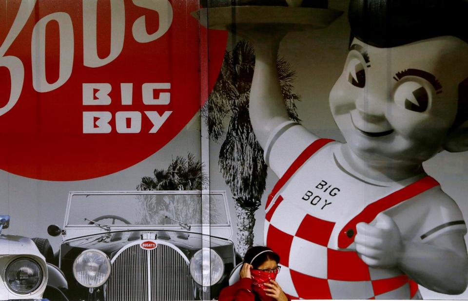 A woman adjusts a bandana around her face before going into the original Bob's Big Boy restaurant in Burbank in 2020.