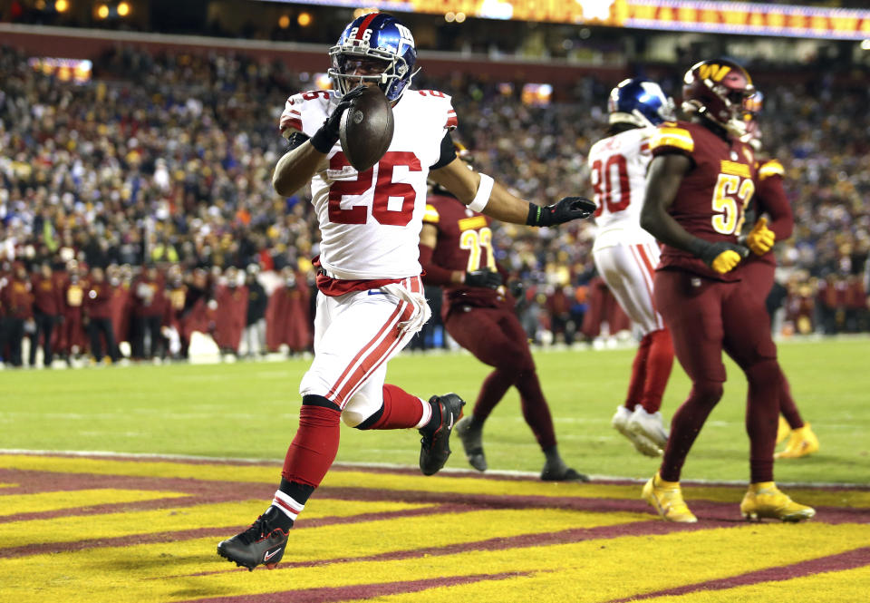 New York Giants running back Saquon Barkley (26) scores a touchdown against the Commanders. (AP Photo/Daniel Kucin Jr.)