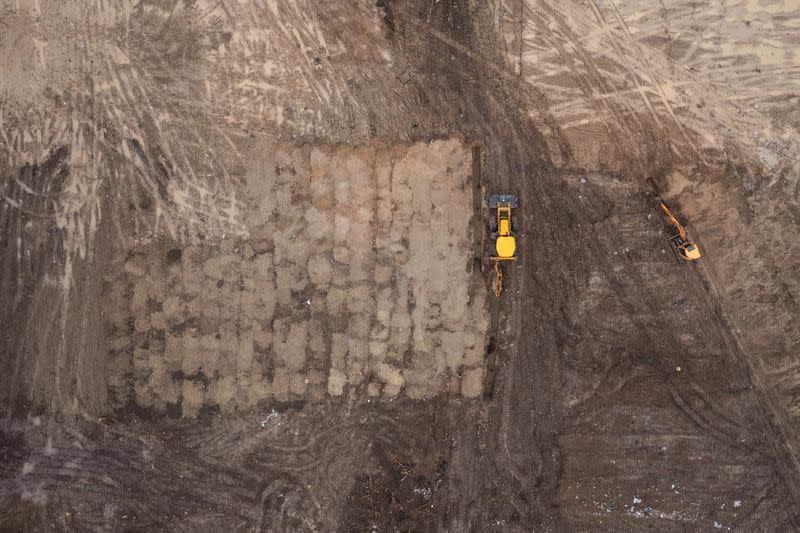 Excavators are seen digging on newly discovered mass grave with 11 bodies near Vukovar