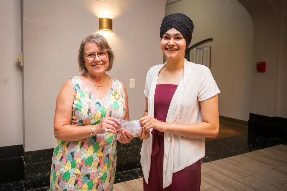 Mary Elliot Nowakowski, a retired archivist for the Mount Mary University fashion archive collection, presents Ritika Singh with a $1,000 check for her education at Hoffstra University.
