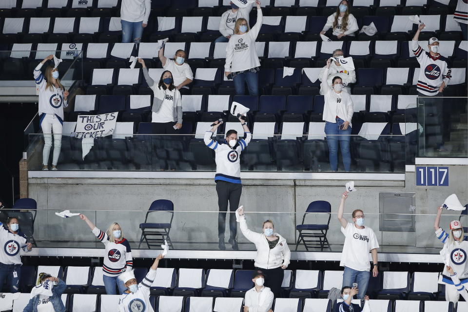 Some of the 500 fans in the stands celebrate celebrate a Winnipeg Jets goal against the Montreal Canadiens during the first period of Game 1 of an NHL hockey Stanley Cup second-round playoff series Wednesday, June 2, 2021, in Winnipeg, Manitoba. (John Woods/The Canadian Press via AP)