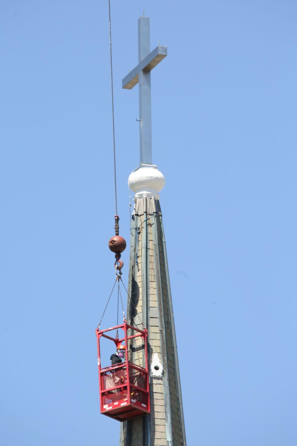 Bryan Dulsky, owner of Detroit Steeplejack, does some much needed restoration work on the steeple of the Saint Joseph Church in Fremont.