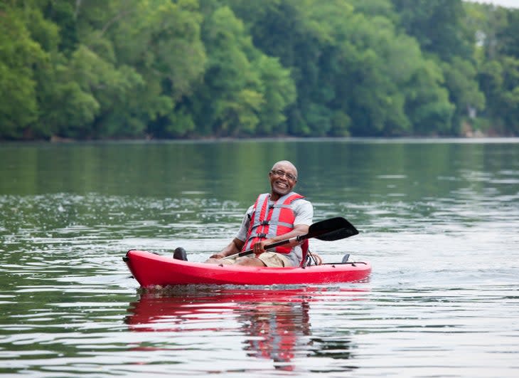 Smiling man kayaking on river