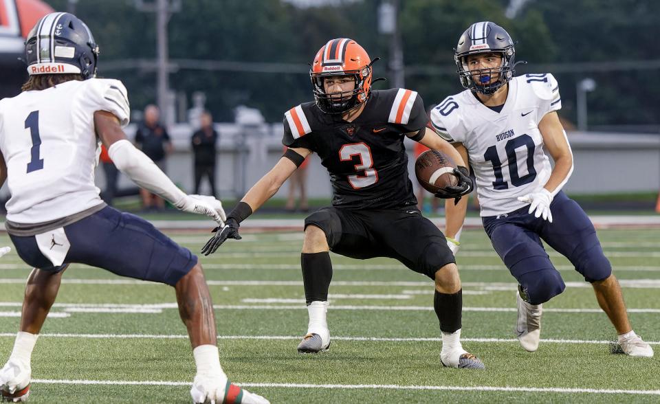 Hoover's Mason Ashby (3) tries to elude Hudson defenders Trey Sharp (1) and Nick Innamorato (10) Friday in North Canton.