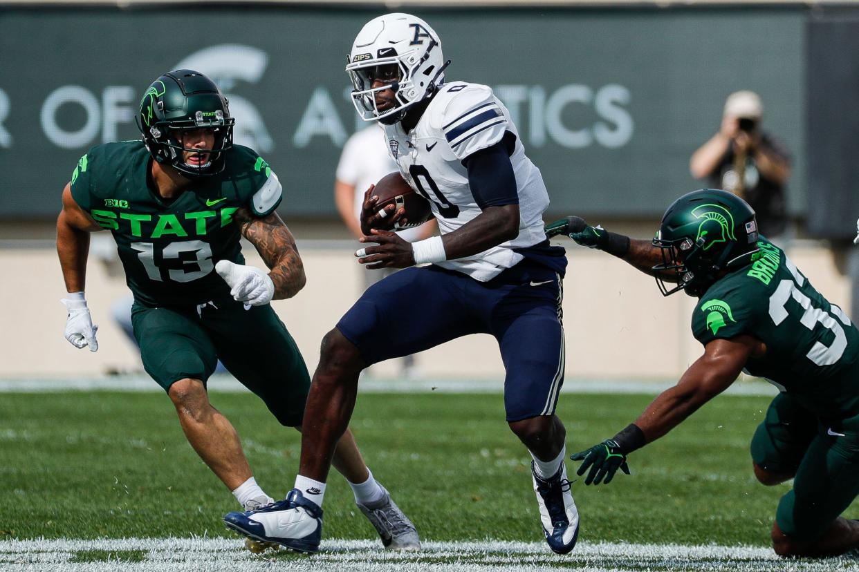 Akron quarterback DJ Irons runs against Michigan State linebacker Ben VanSumeren, left, during the first half at Spartan Stadium in East Lansing on Saturday, Sept. 10, 2022.