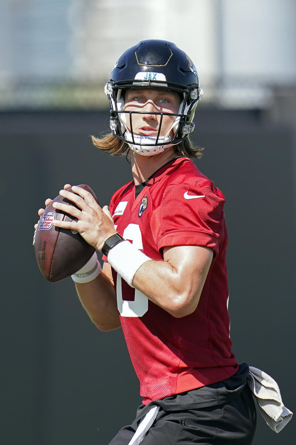 Jacksonville Jaguars quarterback Trevor Lawrence (16) looks for a receiver during NFL football practice, Saturday, July 31, 2021, in Jacksonville, Fla. (AP Photo/John Raoux)