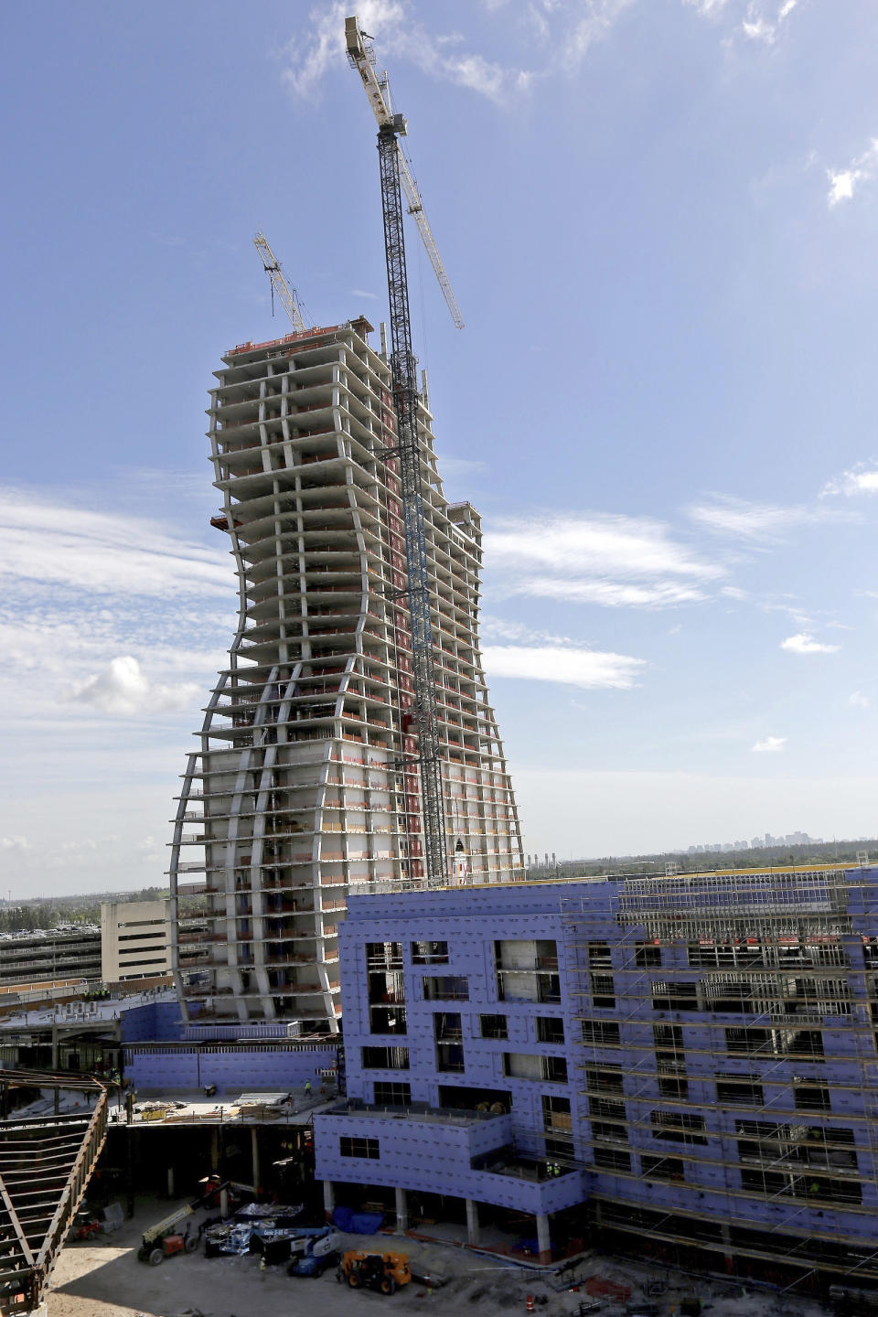 FILE - In this July 9, 2018 file photo, the new guitar tower is constructed as part of the guitar-shaped Seminole Hard Rock Hotel and Casino slated to open next year in Hollywood, Fla. It looks like the guitar Led Zeppelin's Jimmy Page played. But this one is 450 feet (137 meters) tall and is a light-beam hotel that the Seminole Tribe wants to become South Florida's latest tourist destination. The Guitar Hotel's grand opening is Thursday, Oct. 24, 2019, on the tribe's land in Hollywood. It's the latest step in the Seminole Hard Rock empire, which includes naming rights on the Miami-area stadium where the 2020 Super Bowl will be played. (Carl Juste/Miami Herald via AP, File)