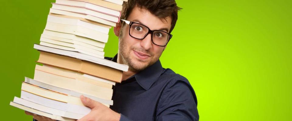 Young Man Holding Stack Of Books On Green Background