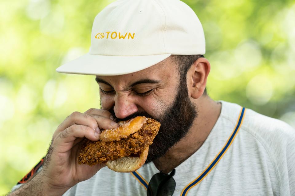 Rateb Aburas, executive chef of Mulberry Street Tavern and the Surety Hotel Des Moines, takes a bite out of the OMG chicken sandwich from Chicken City at the Iowa State Fair.