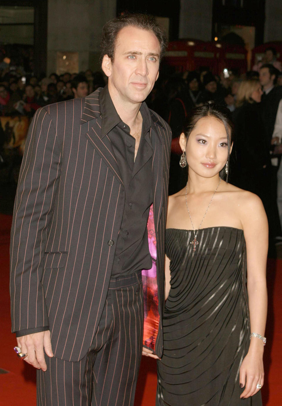 They're on the red carpet; he's in a pin-striped suit and shirt, and she's wearing a strapless dress