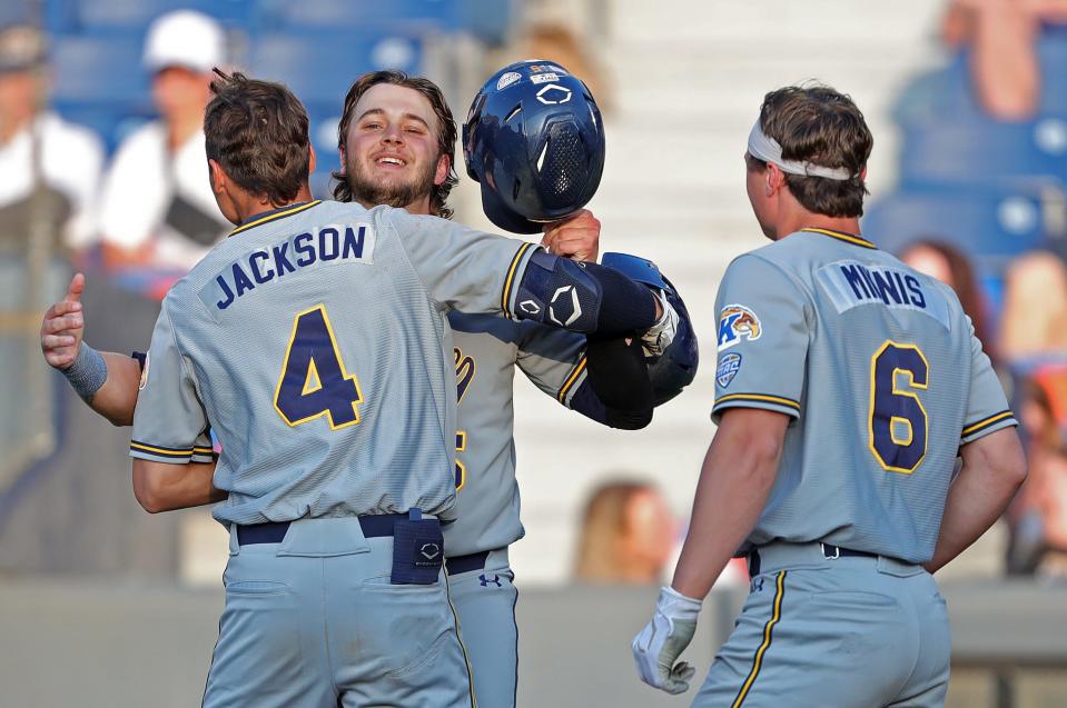 Kent State third baseman Kyle Jackson (4) is greeted at home plate after his three-run home run by first baseman Aidan Longwell (5) during the third inning of an NCAA baseball game against the Akron Zips at Canal Park, Tuesday, May 9, 2023, in Akron, Ohio.