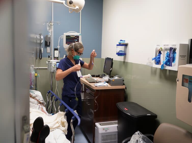 FILE - Registered nurse Sandra Younan sets up a new intravenous line for a patient under her care at Providence Cedars-Sinai Tarzana Medical Center in Los Angeles on March 11, 2021. California officials, on Tuesday, July 19, 2022, announced health insurance rates would increase an average of 6% for the 1.7 million people who purchase coverage through the state run health insurance marketplace, Covered California. Health insurers in individual marketplaces across 13 states and Washington D.C. will raise rates an average of 10% next year. (AP Photo/Damian Dovarganes, file)