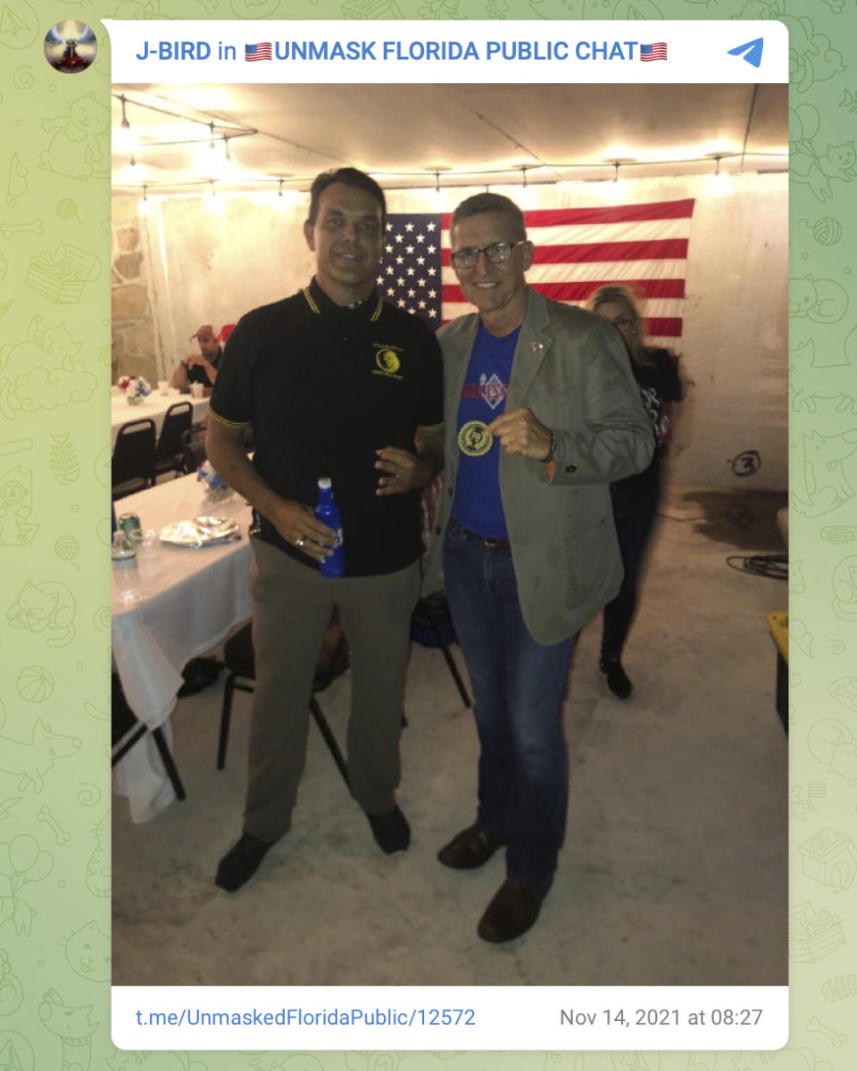 This photo posted on Telegram on Nov. 14, 2021 shows James Hoel, left, with Michael Flynn holding a Proud Boys insignia at The Hollow in Venice, Fla. The Proud Boys are a violent extremist group that has been designated a terrorist organization by the governments of Canada and New Zealand and labeled a hate group by the Southern Poverty Law Center, a nonprofit legal advocacy group. (AP Photo)