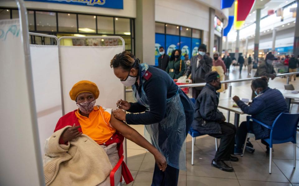 In this July 6, 2021, file photo, a patient receives a Johnson & Johnson vaccine against COVID-19 in Hammanskraal, South Africa. New infections in South Africa rose to record levels in recent days, part of a rapid rise across the continent, and experts say the surge here has not yet peaked. South Africa reimposed several restrictions, and its vaccination drive is finding its feet after several stumbles. But even as the campaign gathers pace, experts say it's too late to reduce the deadly impact of the current spike. - AP