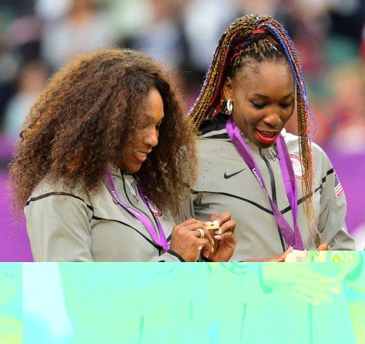 US Serena Williams (L) and Venus Williams stand on the podium after receiving their gold medals for winning the London 2012 Olympic Games women's doubles tennis tournament, at the All England Tennis Club in Wimbledon, southwest London