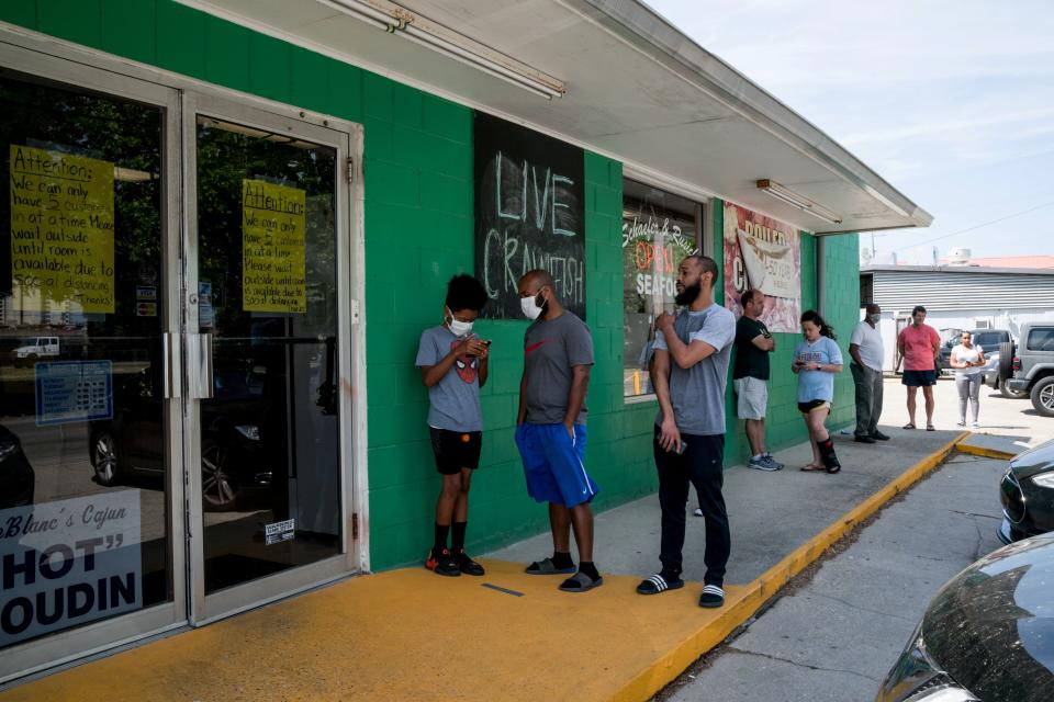 Customers practice social distancing while waiting to buy seafood at Schaefer Seafood in New Orleans, Louisiana on April 11, 2020. - Louisiana residents adapt to Coronavirus restrictions at a time when they would normally gather for traditional Easter crawfish boils. (Photo by Claire BANGSER / AFP) (Photo by CLAIRE BANGSER/AFP via Getty Images)