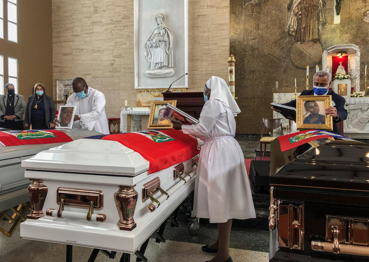 Church officials set up photos of the 11 Haitian women who died last month when the overloaded boat they were in capsized, at a church in San Juan, Puerto Rico