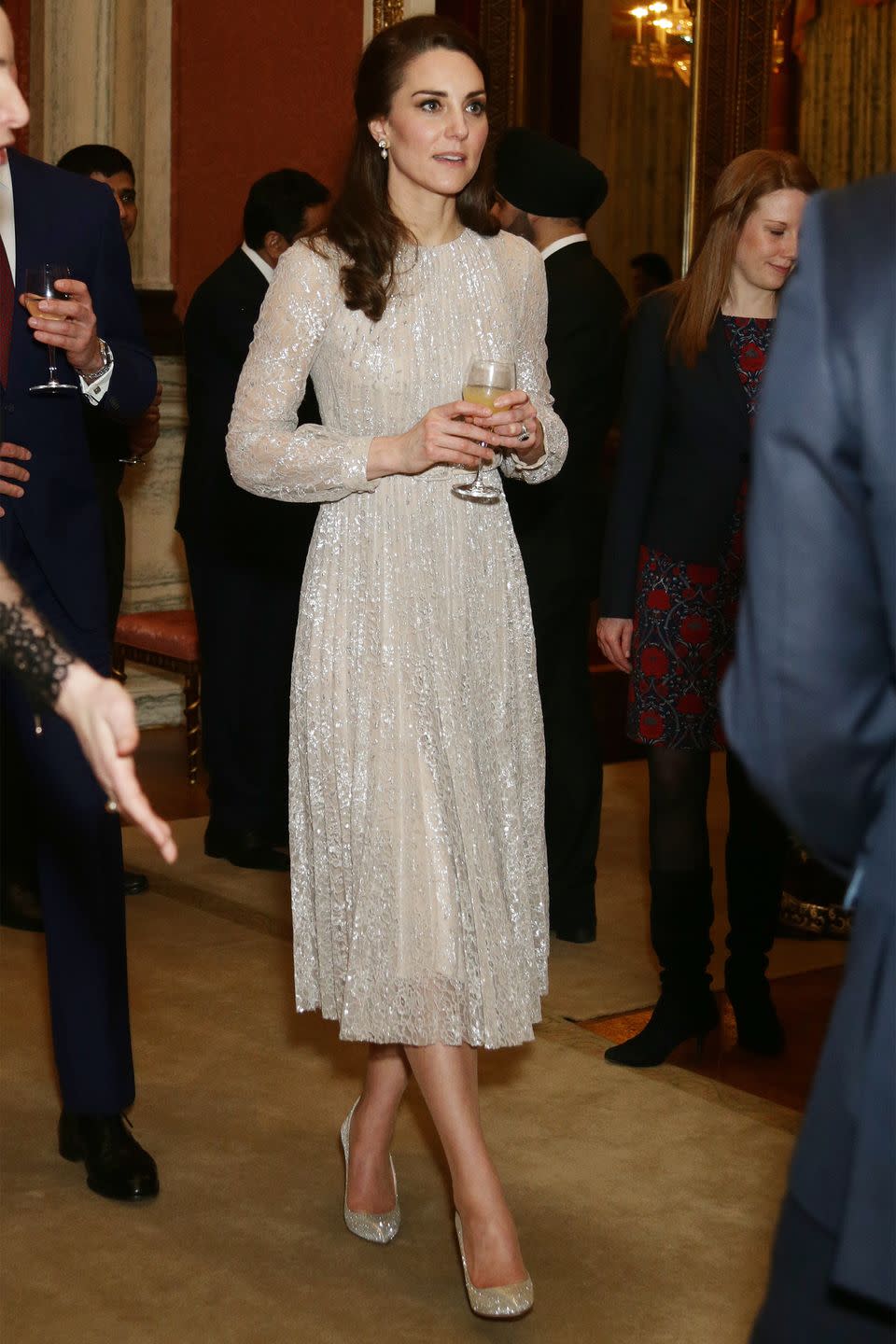 <p>The Duchess wears a shimmering, champagne-colored Erdem dress with dangling pearl earrings and glittery pumps at Buckingham Palace.</p>