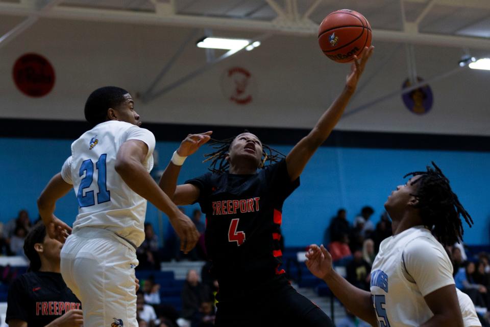 Freeport's Kazion Morehead (4) and Guilford's Cinco Gary (21) and Milli'on Riley (55) jump for a rebound during a game on Jan. 31, 2024 at Guilford High School.