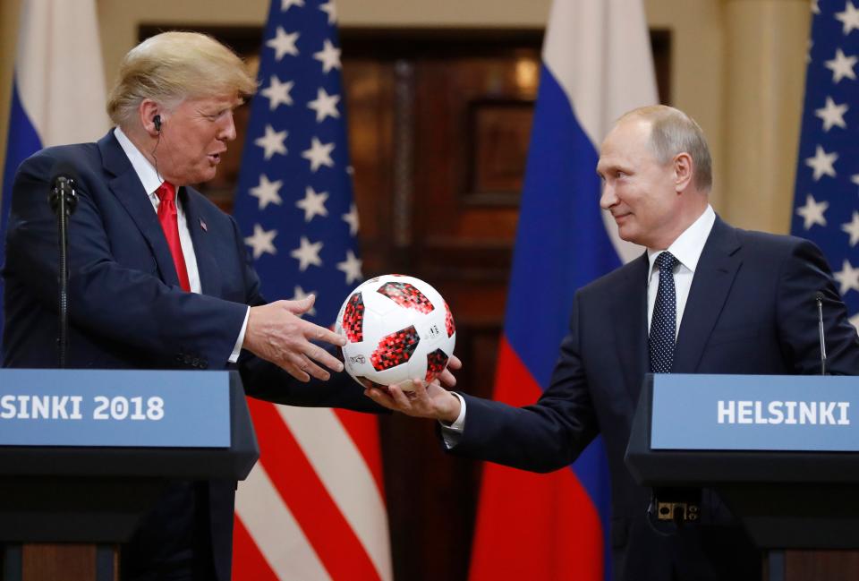 Russian President Vladimir Putin gives a soccer ball to President Donald Trump, left, during a press conference after their meeting at the Presidential Palace in Helsinki, Finland, July 16, 2018.