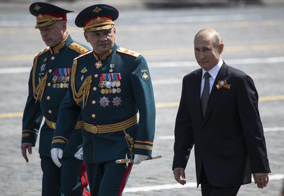 Russian President Vladimir Putin, right, and, Defense Minister Sergei Shoigu, center, leave Red Square after the Victory Day military parade marking the 75th anniversary of the Nazi defeat in Moscow, Russia, Wednesday, June 24, 2020. Russian President Vladimir Putin hailed the defeat of Nazi Germany at the traditional massive Red Square military parade, which was delayed by more than a month because of the invisible enemy of the coronavirus. The parade is usually held May 9 on Victory Day, Russia's most important secular holiday but was postponed until Wednesday due to the pandemic. (AP Photo/Pavel Golovkin, Pool)