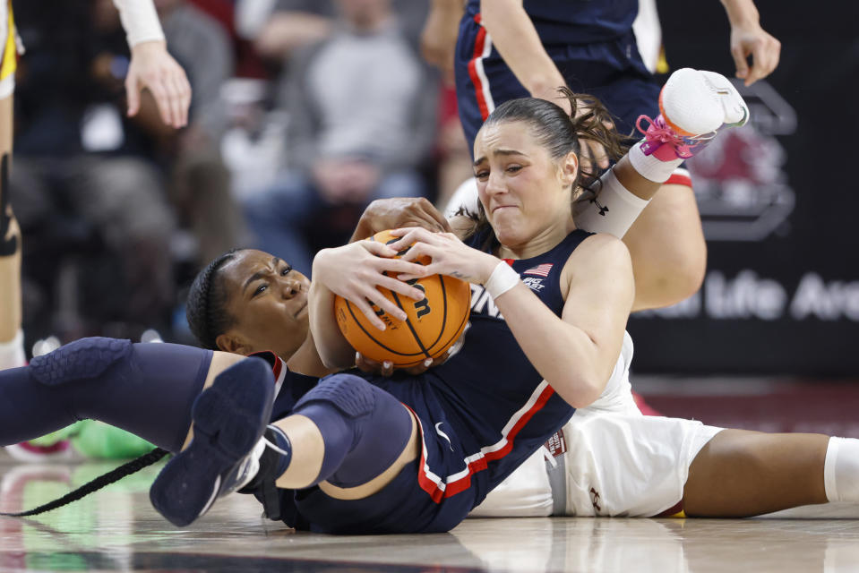 UConn guard Nika Muhl, right, battles South Carolina guard Bree Hall, left, for the ball during the first half of an NCAA college basketball game in Columbia, S.C., Sunday, Feb. 11, 2024. (AP Photo/Nell Redmond)