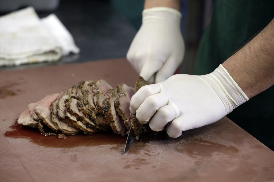 In this Dec. 11, 2013 photo, a "spiced round," a Christmastime beef specially, is sliced at the Porter Road Butcher in Nashville, Tenn. The specialty meat, reminiscent of corned beef, has all but disappeared in recent decades amid changing tastes and the steady decline of local butchers to prepare it. (AP Photo/Mark Humphrey)