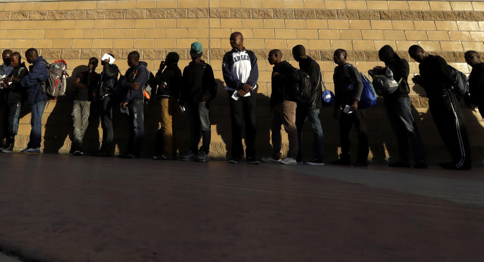 FILE - Haitian migrants line up as they wait to enter the U.S. border crossing, Friday, Sept. 2, 2016, in Tijuana, Mexico. Though Haitians living in the U.S. rejoiced when a recent extension was granted, Homeland Security Secretary Alejandro Mayorkas pointedly noted that it doesn't apply to Haitians outside the U.S. and said those who enter the country may be flown home. That means bleak choices for many Haitians who fled Haiti sometime after a 2010 earthquake, initially escaping to South America and later to Mexican cities that border the United States. (AP Photo/Gregory Bull)