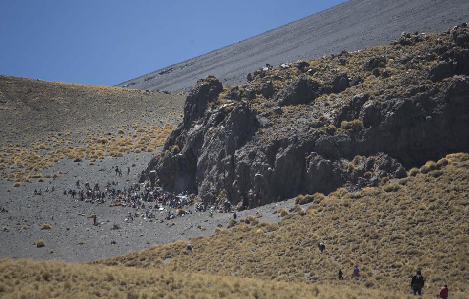 ARCHIVO - Pobladores que viven cerca del volcán Popocatépetl suben por sus laderas hasta una formación rocosa para hacer ofrendas y tocar música para pedirle a la montaña que los libre de sus erupciones, en México, el 12 de marzo de 2014. Cuando amanece, cientos de peregrinos se dirigen desde los pueblos de Santiago Xalintzintla, Tlamacas y San Nicolás de Los Ranchos, primero en camioneta o camiones y luego a pie, hacia el volcán para un día de celebración. (AP Foto/Eduardo Verdugo, Archivo)