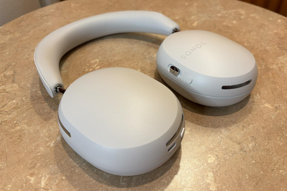<p>White headphones laying flat on a small table, ear cups rotated so they lay flat.</p>
