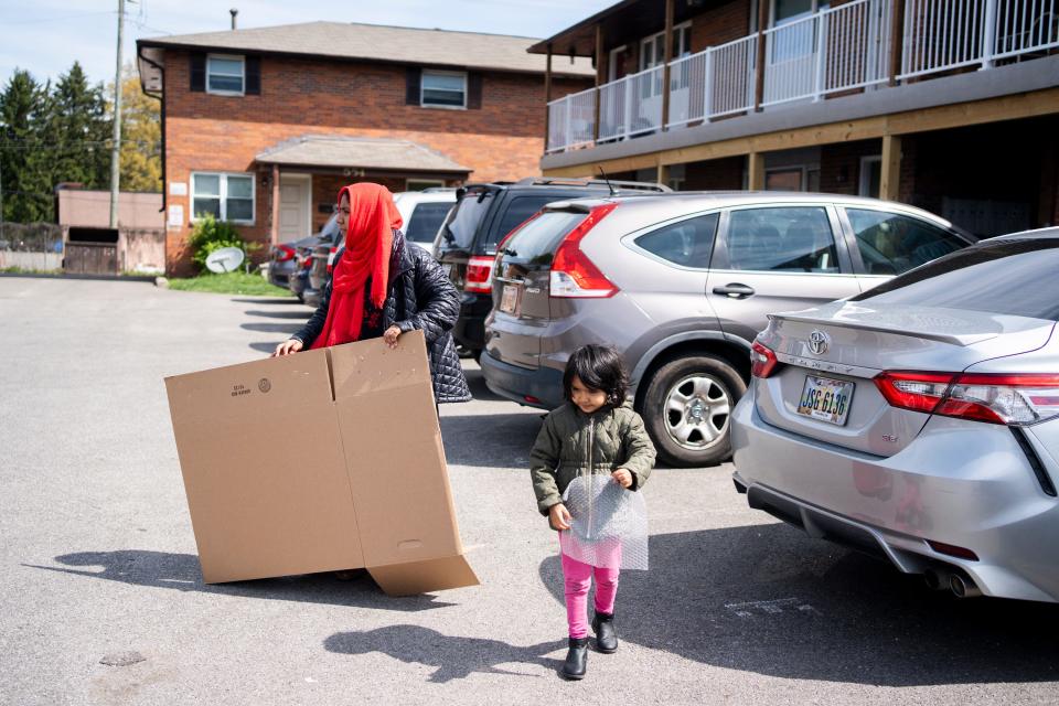Shahida Akther carries a box as she prepares to move out of her apartment, which was bought by a new owner who is not issuing new leases to over 80 households.