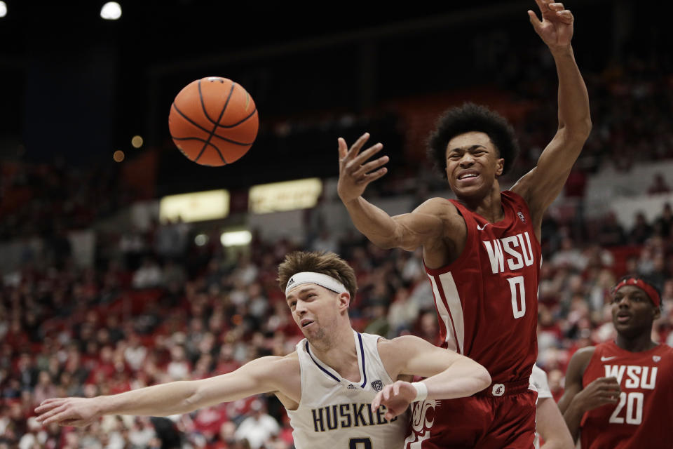 Washington guard Paul Mulcahy, left, and Washington State forward Jaylen Wells (0) go after a rebound during the first half of an NCAA college basketball game, Thursday, March 7, 2024, in Pullman, Wash. (AP Photo/Young Kwak)