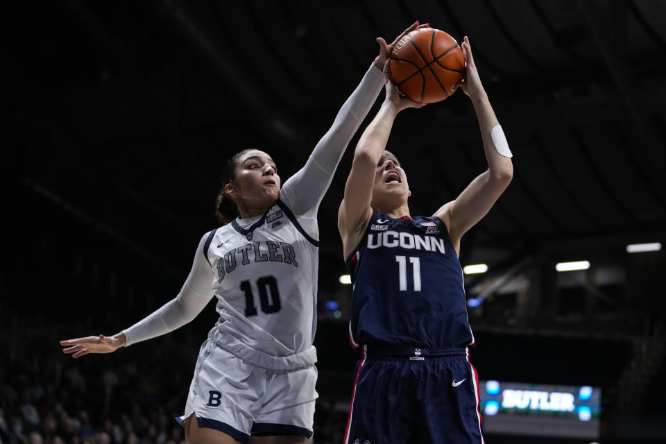 Butler guard Trinity White (10) blocks the shot of UConn forward Lou Lopez Senechal (11) during the second half of an NCAA college basketball game in Indianapolis, Tuesday, Jan. 3, 2023. (AP Photo/Michael Conroy)