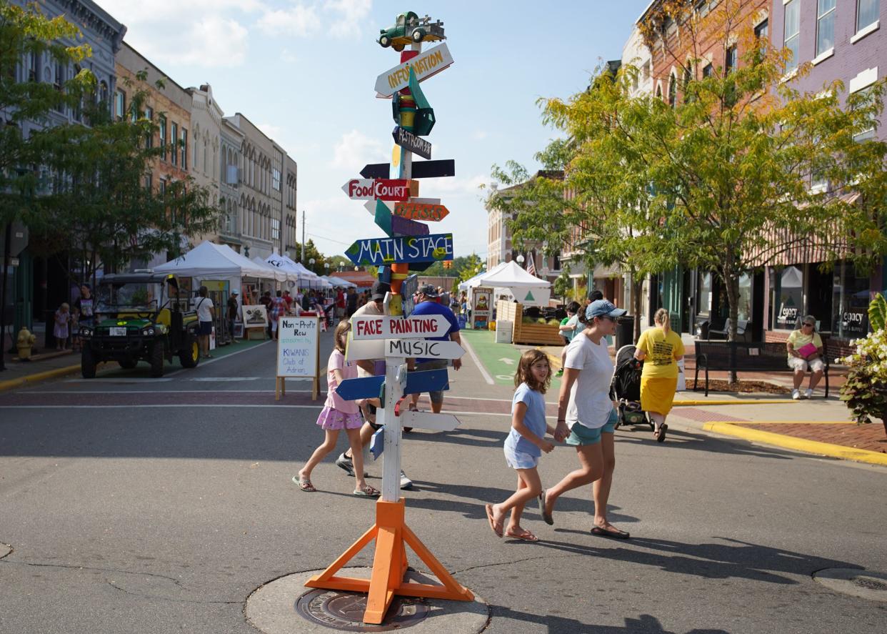 The sign post at the four corners in downtown Adrian directs people to the many attractions at the Artalicious Fine Arts Fair Saturday, Sept. 17, 2022.