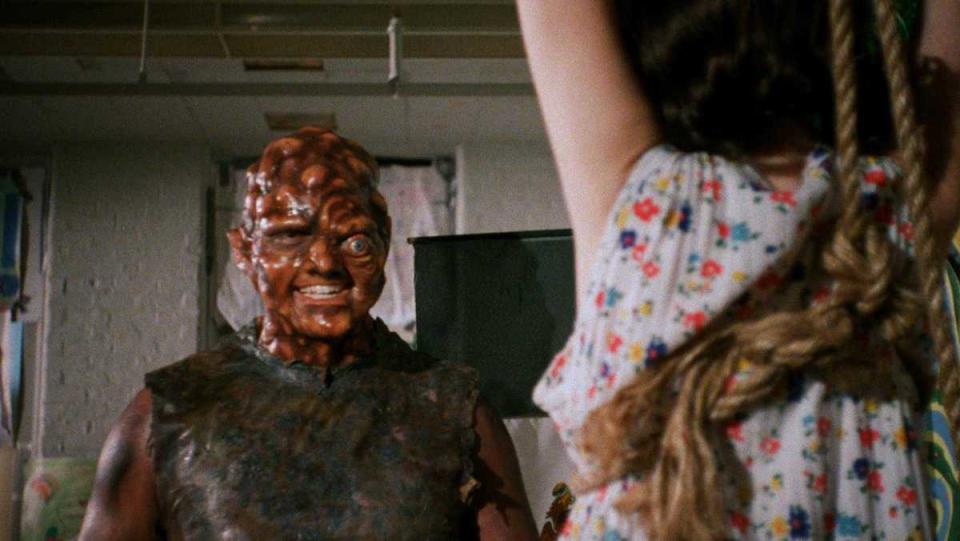 The Toxic Avenger smiles at a woman who is ostensibly tied up