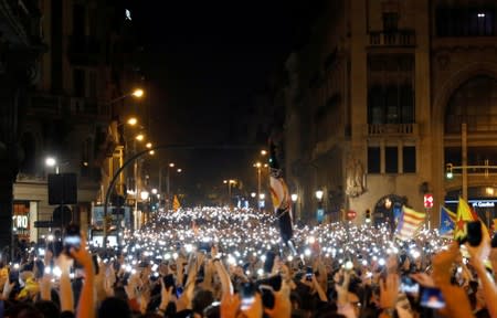 Demonstrators hold up their phones during a protest after a verdict in a trial over a banned independence referendum, in Barcelona