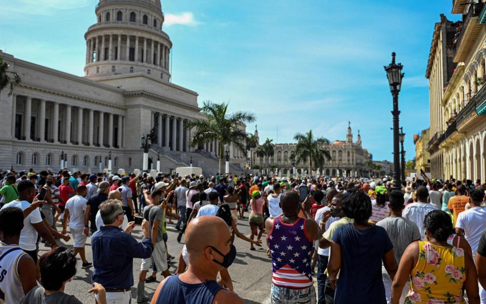 Cubans are seen outside Havana's Capitol during a demonstration against the government of Cuban President Miguel Diaz-Canel in Havana, on July 11, 2021. - Thousands of Cubans took part in rare protests Sunday against the communist government, marching through a town chanting "Down with the dictatorship" and "We want liberty." - AFP