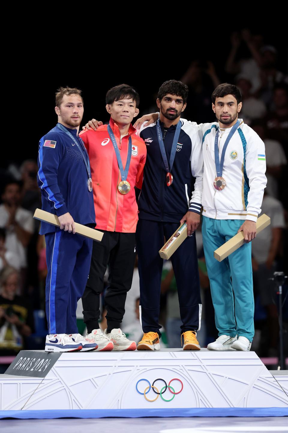 American wrestler Spencer Lee (left) stands on the Olympic podium after winning silver in his 57 kg match on Friday.