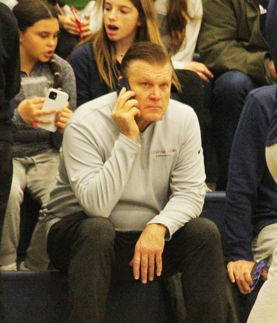 University of Illinois basketball coach Brad Underwood takes a call during halftime of the Pontiac-Central Catholic basketball game in Bloomington Friday.